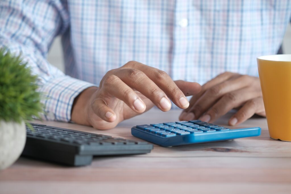 Accountant calculating tax return for business on calculator